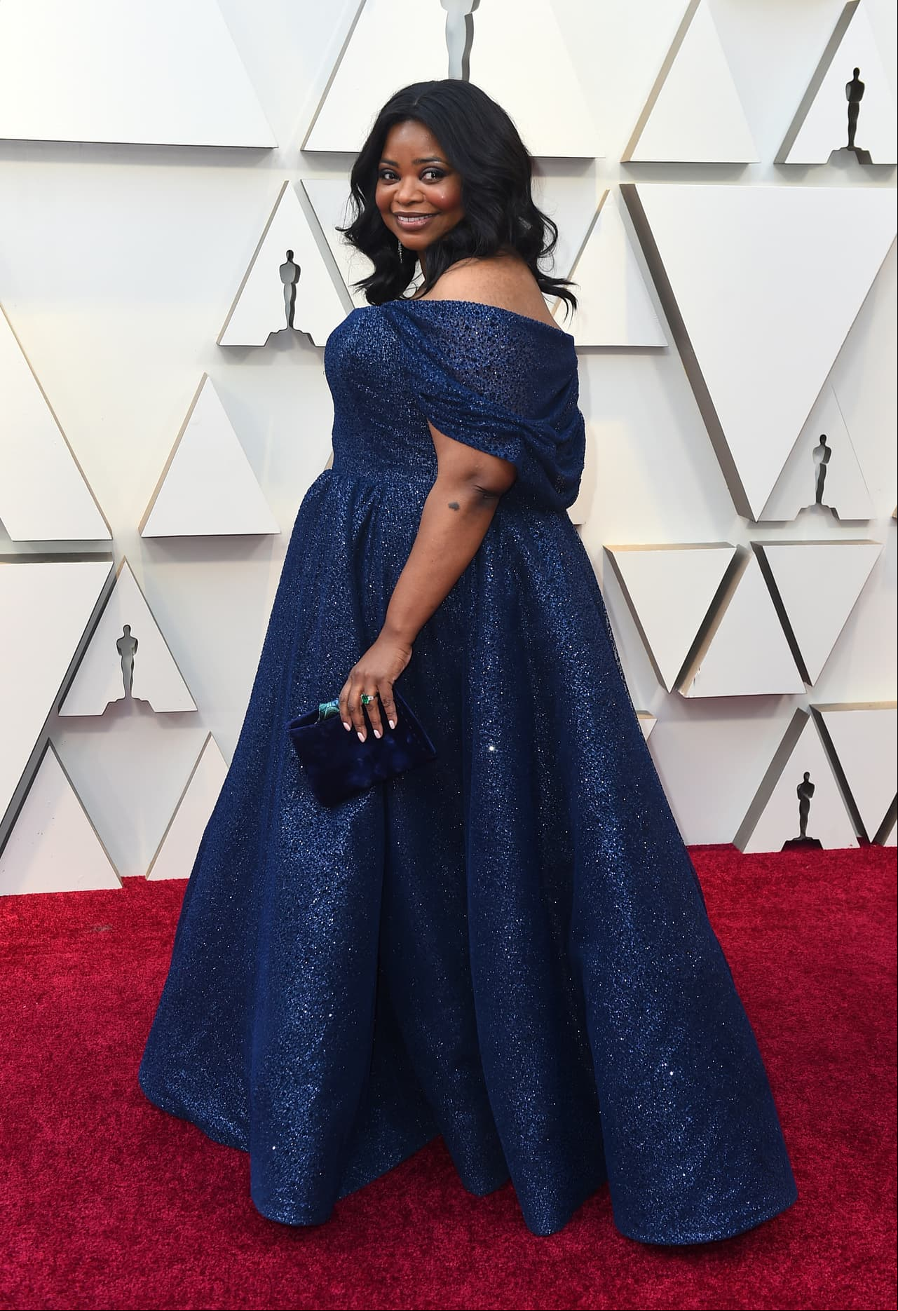 Octavia Spencer brilló a su paso en la alfombra con un vestido azul coordinado con una bolsa de mano.