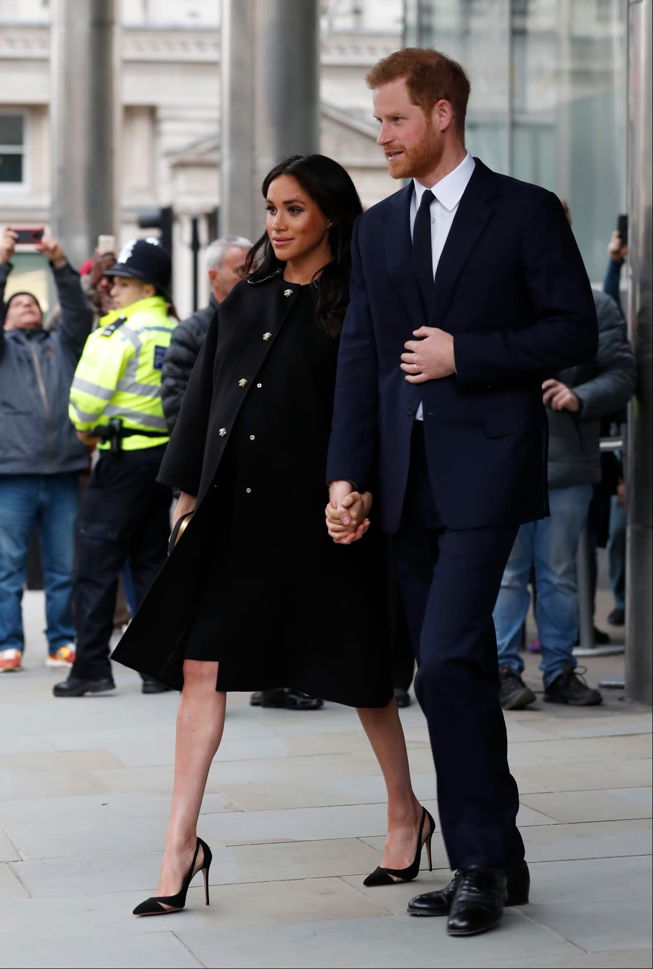 Junto al príncipe Harry, la duquesa guardó luto con un abrigo y clutch negro Gucci, que complementó con un par de zapatillas Aquazzura.
