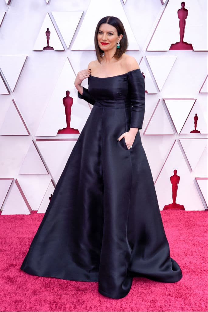 Laura Pausini impresionó al lucir un vestido negro de corte princesa y falda amplia de la firma Valentino; su look lo complementó con pendientes largos brillantes en color plata con un toque verde.