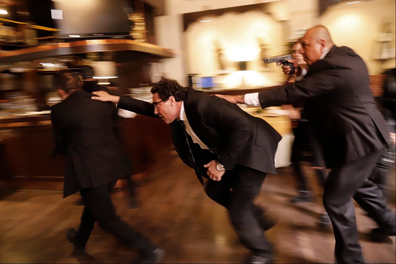 Con ayuda de su equipo de seguridad, el presidente logra escapar del lugar.