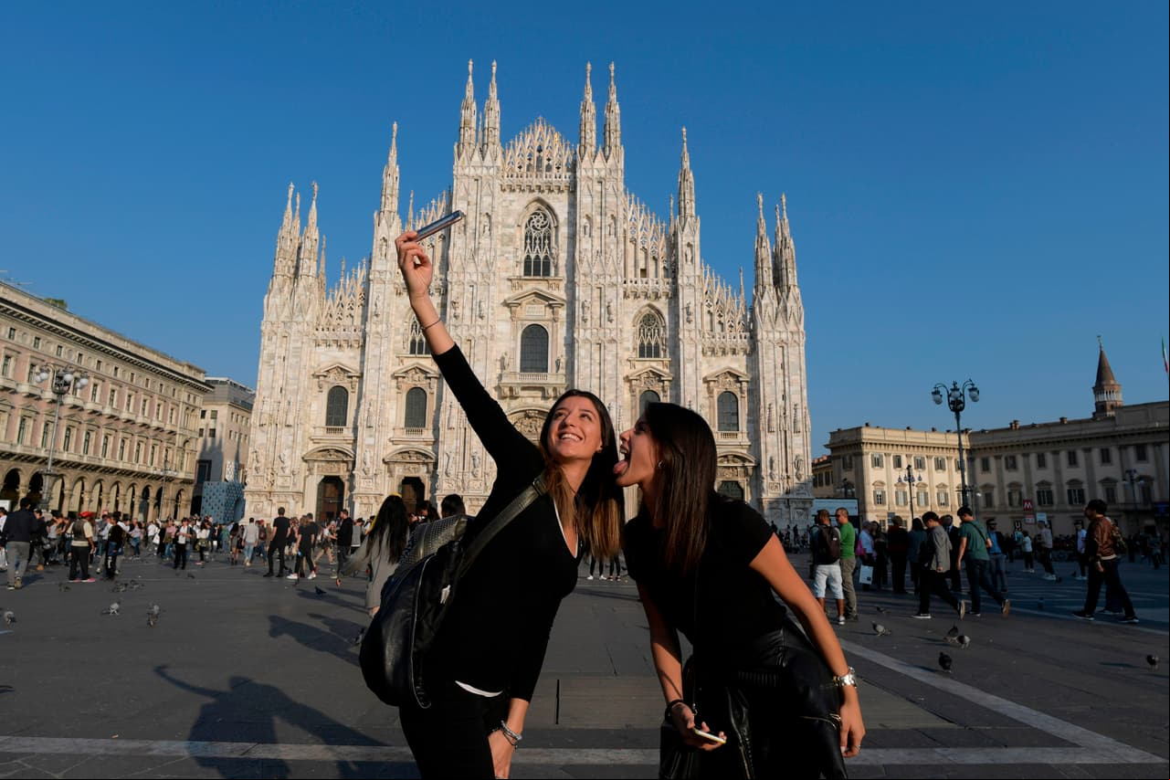 Tourists snap a selfie in front of the Duomo cathedral in Milan on October 13, 2017. / AFP PHOTO / MIGUEL MEDINA (Photo credit should read MIGUEL MEDINA/AFP via Getty Images)