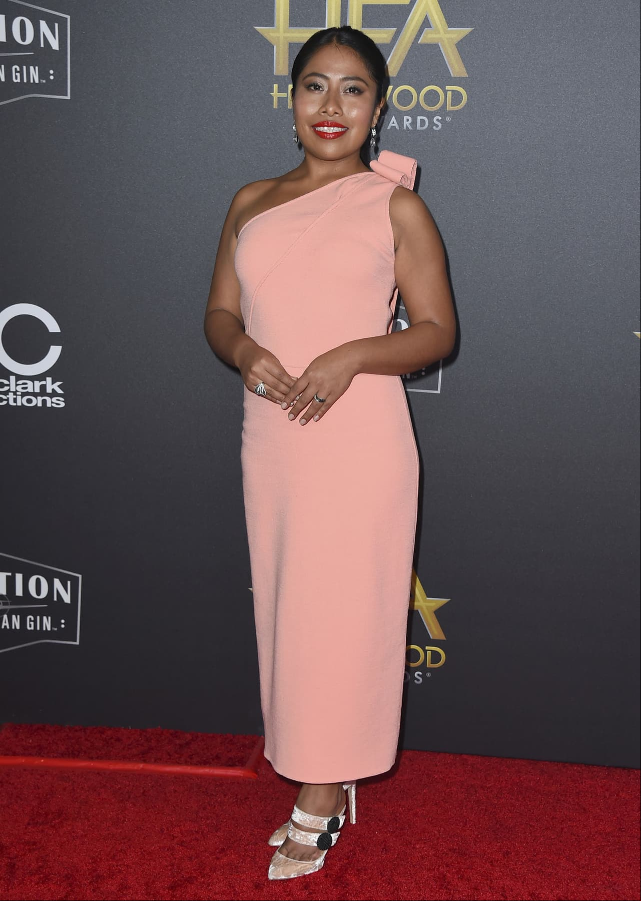 Yalitza desfiló en la alfombra roja de los Hollywood Film Awards con un vestido de un solo hombro en color durazno de Oscar de la Renta y unas zapatillas de gamuza del mismo tono de Chloe Gosselin.