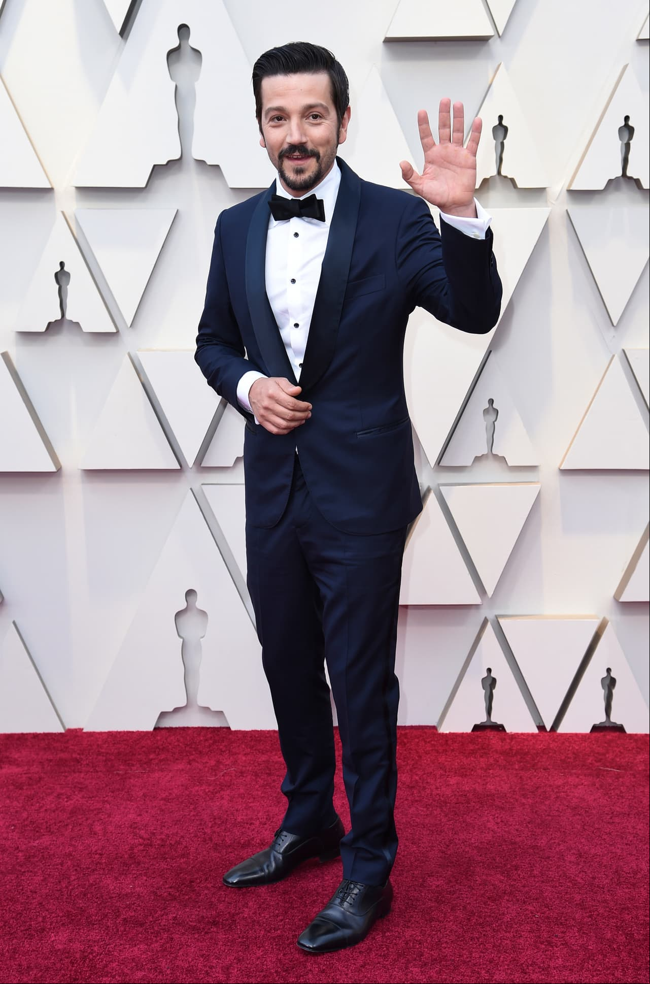 El mexicano Diego Luna, pulcro, elegante y soriente con un traje azul marino.