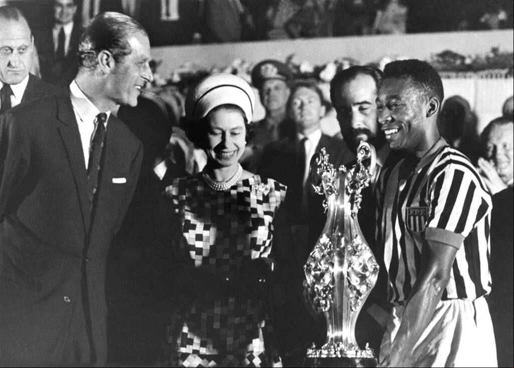 La llegada de Pelé al Cosmos de Nueva York ayudó a aumentar aún más su fama. Fue cortejado por presidentes,  de la realeza y estrellas de rock.
<br>
<br>En esta foto de archivo del 10 de noviembre de 1968, la reina Isabel II de Gran Bretaña con el príncipe Felipe entrega una copa al futbolista Pelé, a la derecha, en un estadio en Río de Janeiro, Brasil, durante una gira estatal por Sudamérica.